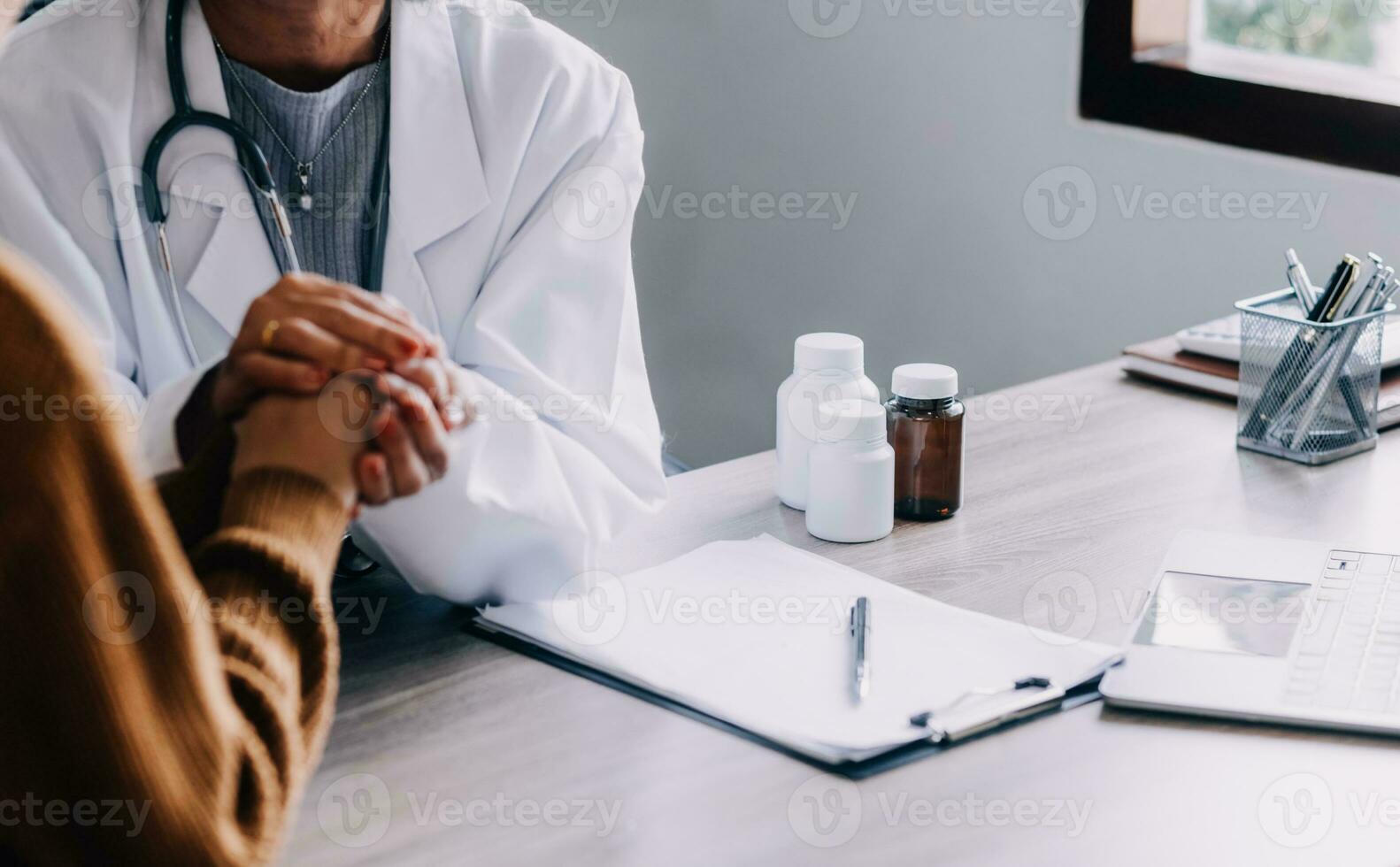 Young psychologist holding hand of her patient in need while consulting her after discussion of problem photo