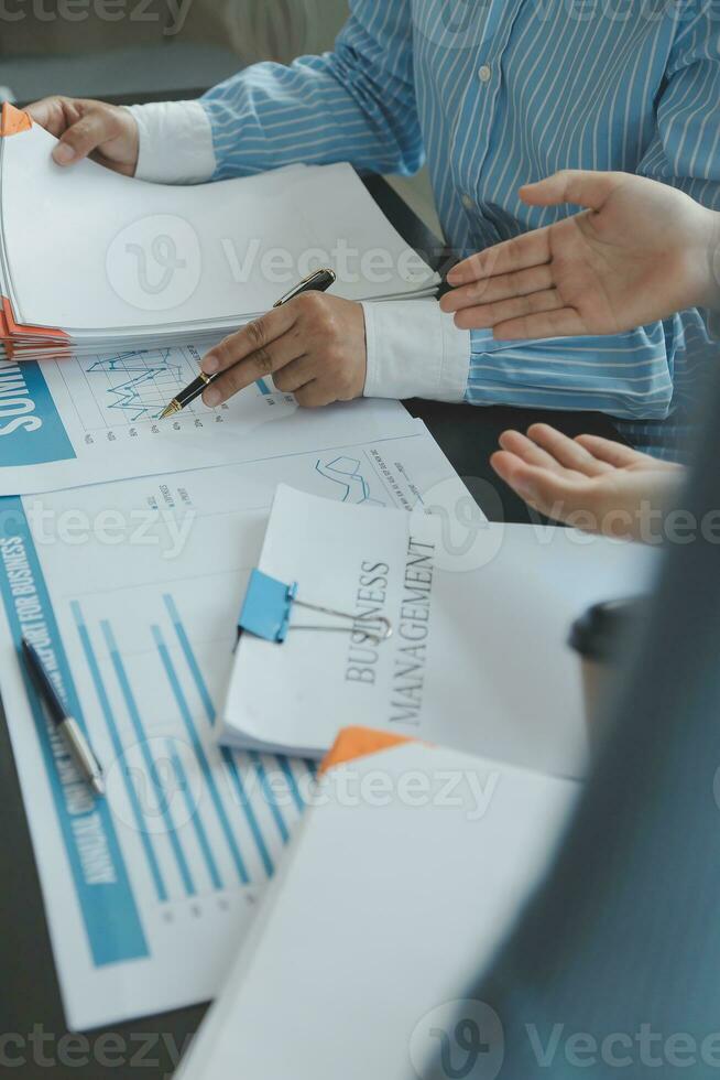 Financial analysts analyze business financial reports on a digital tablet planning investment project during a discussion at a meeting of corporate showing the results of their successful teamwork. photo
