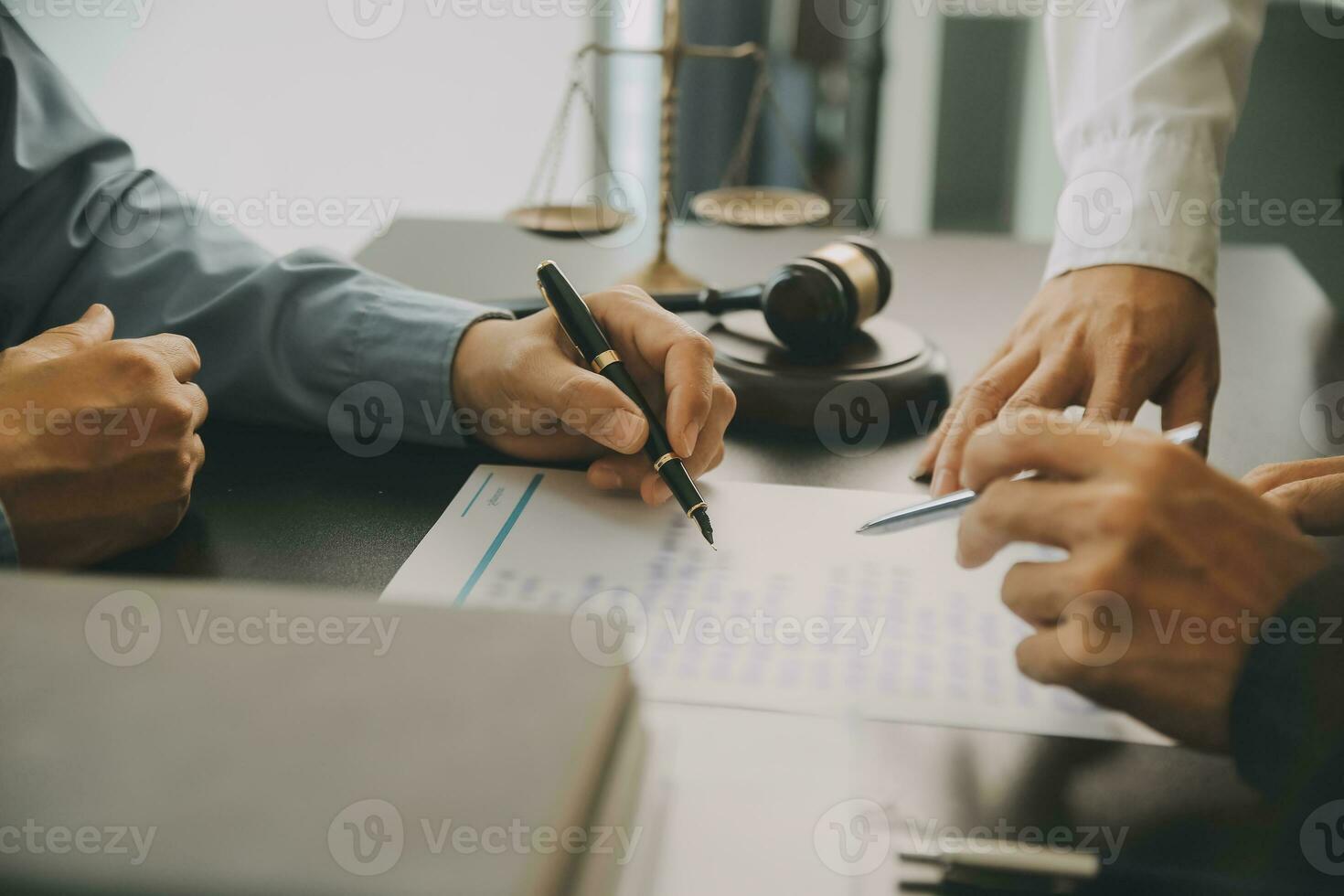 Business and lawyers discussing contract papers with brass scale on desk in office. Law, legal services, advice, justice and law concept picture with film grain effect photo