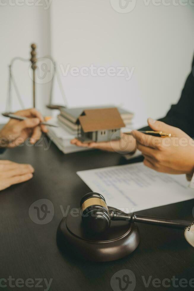 Business and lawyers discussing contract papers with brass scale on desk in office. Law, legal services, advice, justice and law concept picture with film grain effect photo