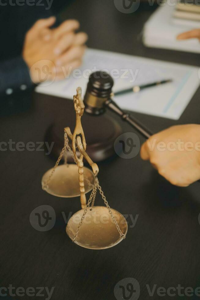 Business and lawyers discussing contract papers with brass scale on desk in office. Law, legal services, advice, justice and law concept picture with film grain effect photo