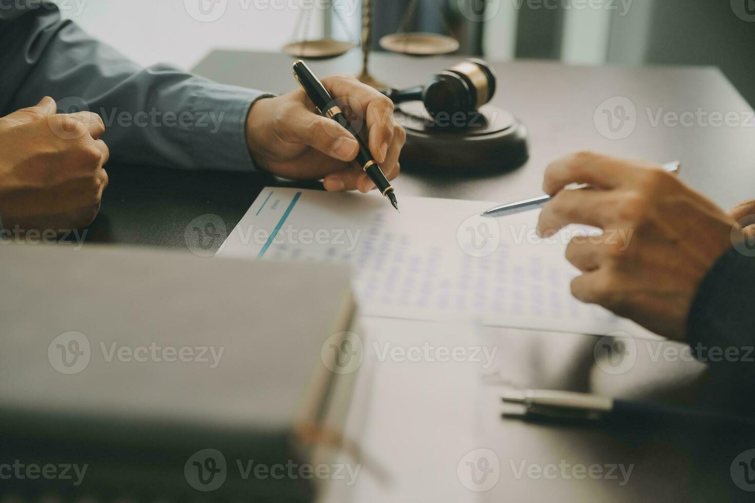 Business and lawyers discussing contract papers with brass scale on desk in office. Law, legal services, advice, justice and law concept picture with film grain effect photo