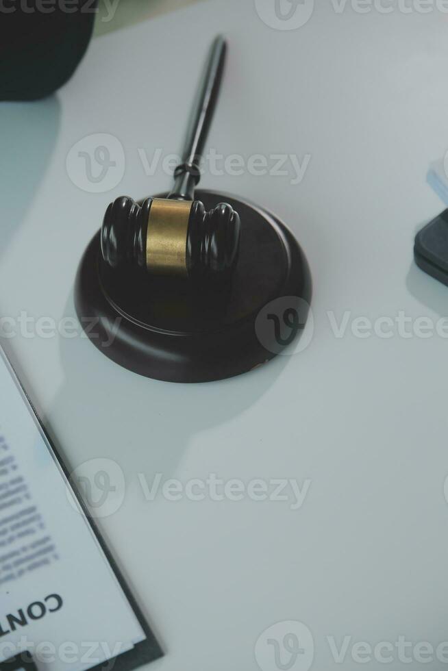 Business and lawyers discussing contract papers with brass scale on desk in office. Law, legal services, advice, justice and law concept picture with film grain effect photo