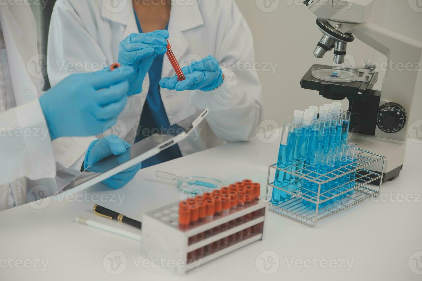Health care researchers working in life science laboratory. Young female research scientist and senior male supervisor preparing and analyzing microscope slides in research lab. photo