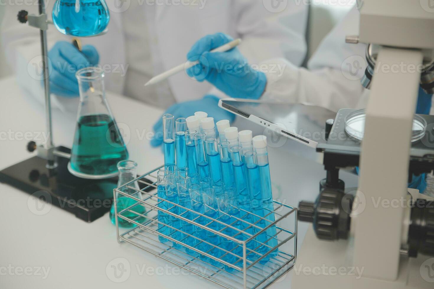 Health care researchers working in life science laboratory. Young female research scientist and senior male supervisor preparing and analyzing microscope slides in research lab. photo