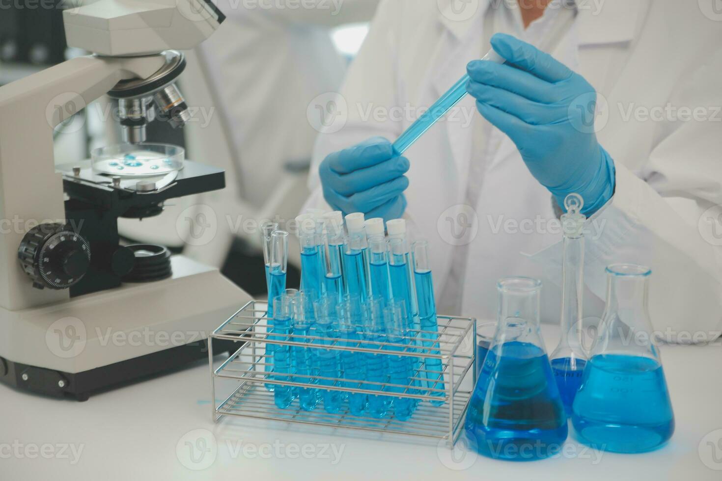 Health care researchers working in life science laboratory. Young female research scientist and senior male supervisor preparing and analyzing microscope slides in research lab. photo