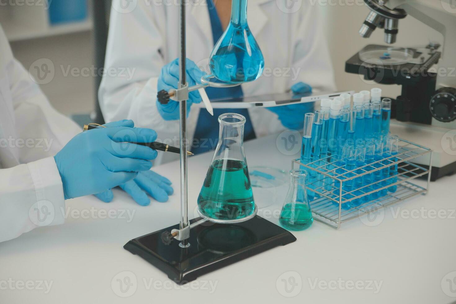 Health care researchers working in life science laboratory. Young female research scientist and senior male supervisor preparing and analyzing microscope slides in research lab. photo