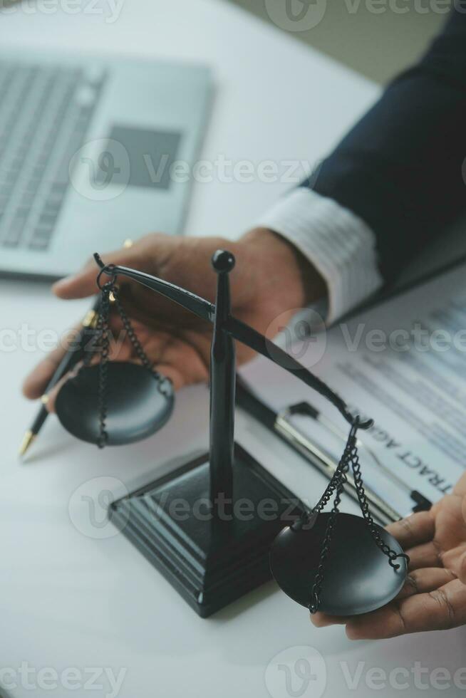 Business and lawyers discussing contract papers with brass scale on desk in office. Law, legal services, advice, justice and law concept picture with film grain effect photo