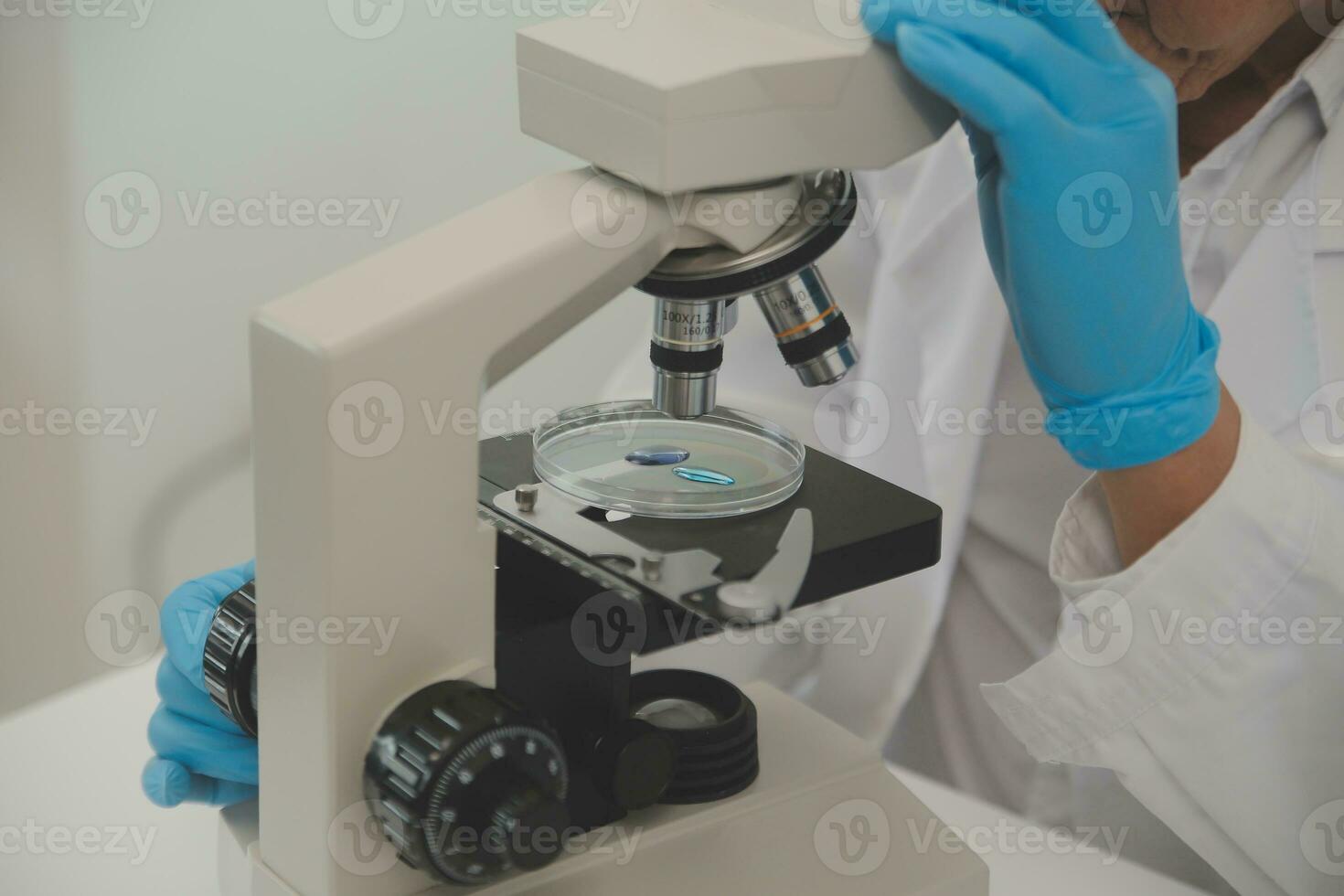 Health care researchers working in life science laboratory. Young female research scientist and senior male supervisor preparing and analyzing microscope slides in research lab. photo