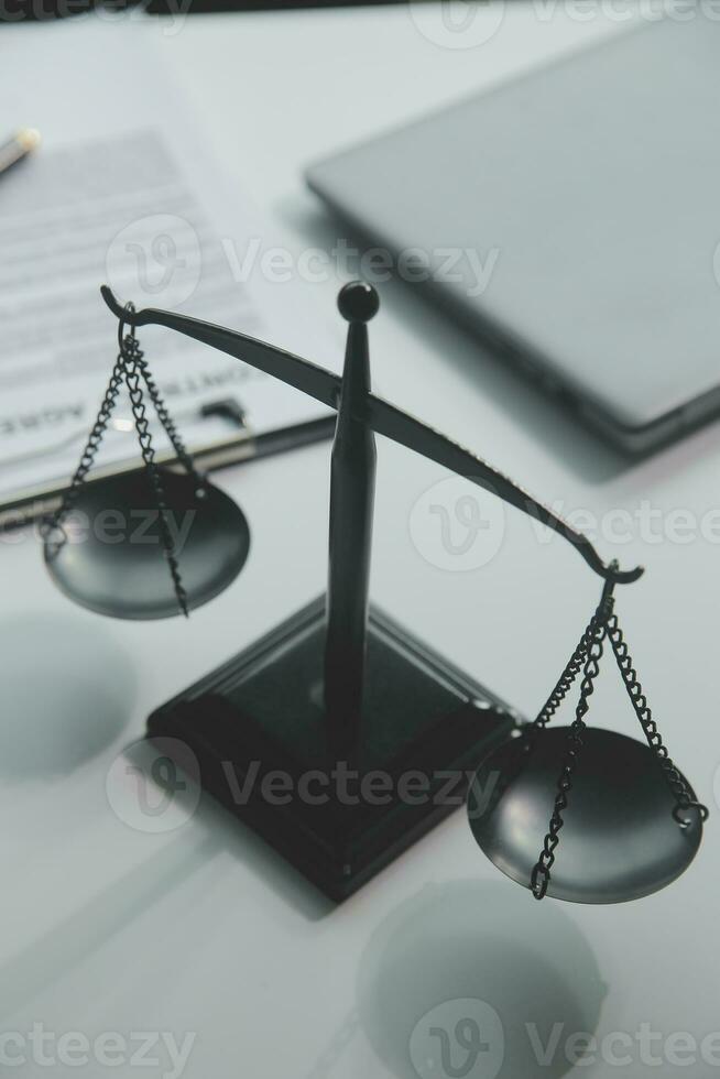 Business and lawyers discussing contract papers with brass scale on desk in office. Law, legal services, advice, justice and law concept picture with film grain effect photo