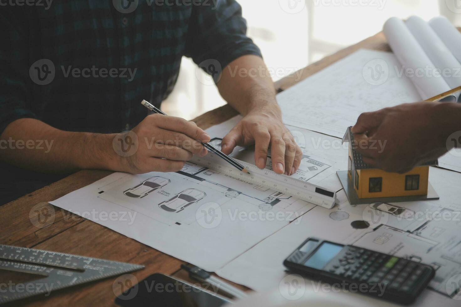 Close up of civil male engineer asian working on blueprint architectural project at construction site at desk in office. photo