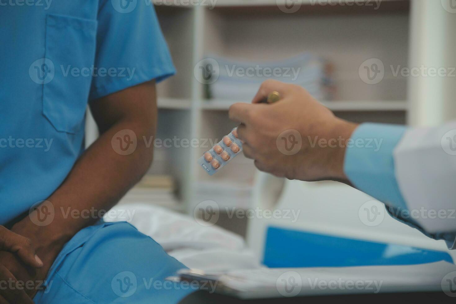 Close up of doctor sitting on bedside of male patient in hospital photo
