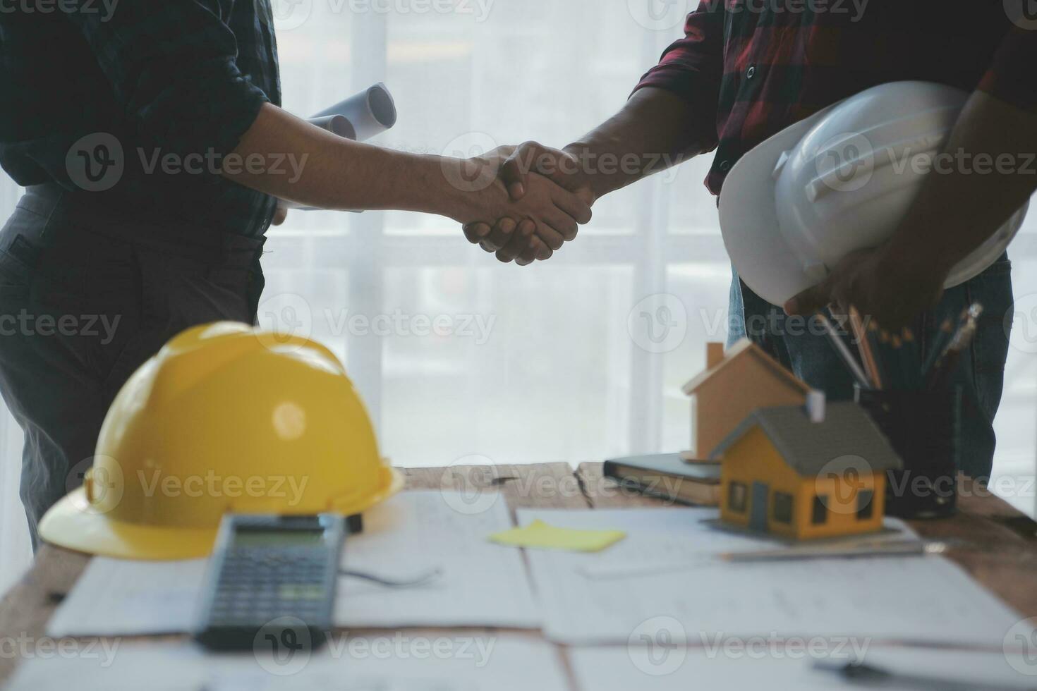 Close up of civil male engineer asian working on blueprint architectural project at construction site at desk in office. photo