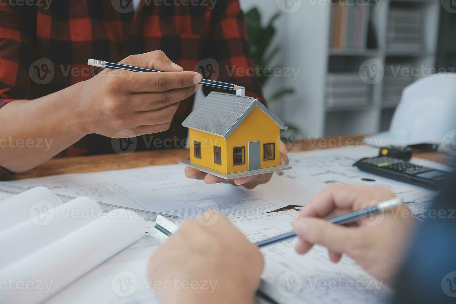 Close up of civil male engineer asian working on blueprint architectural project at construction site at desk in office. photo