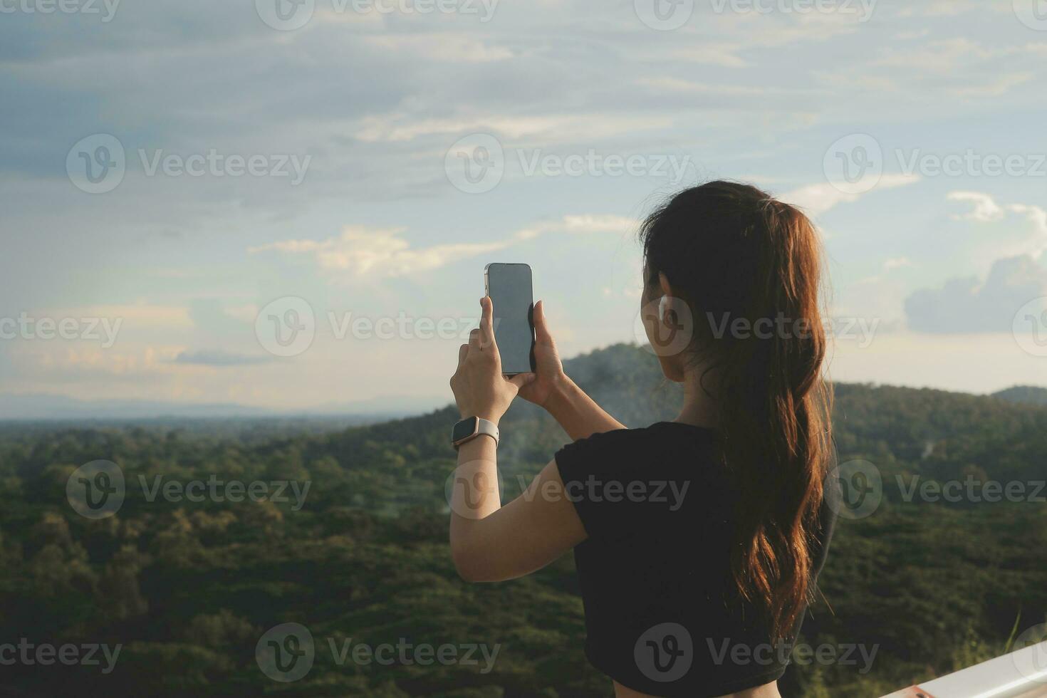 Young woman traveler in casual clothes with backpack from back on background of beautiful view on mountains photo