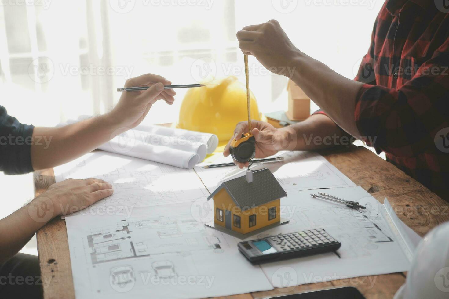Close up of civil male engineer asian working on blueprint architectural project at construction site at desk in office. photo