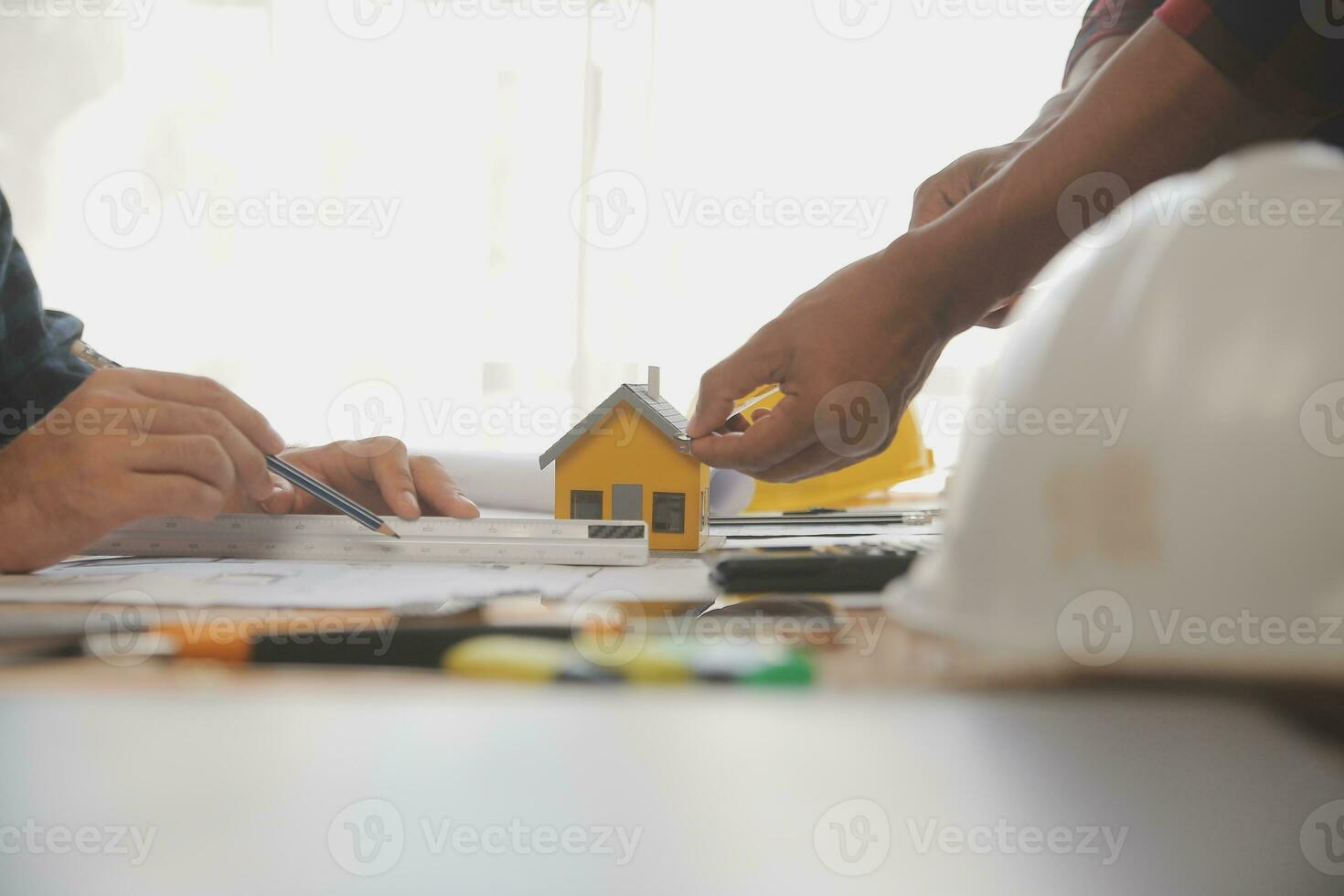 Close up of civil male engineer asian working on blueprint architectural project at construction site at desk in office. photo