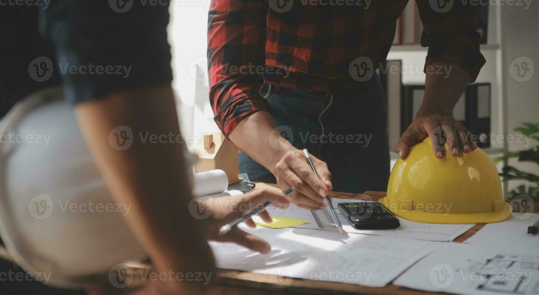 Close up of civil male engineer asian working on blueprint architectural project at construction site at desk in office. photo