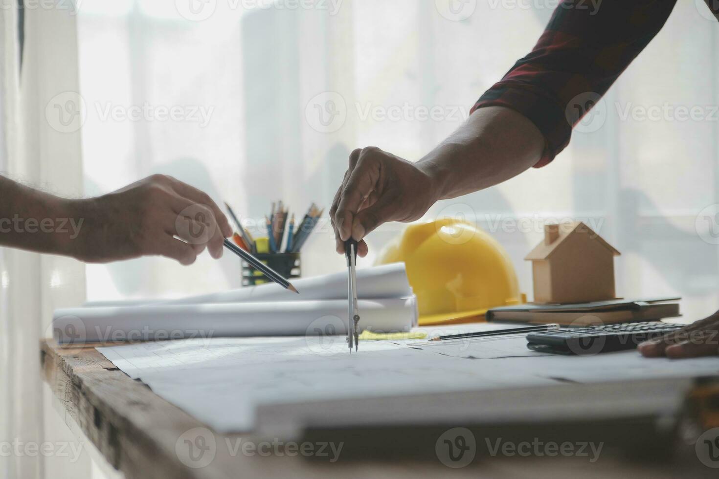 Close up of civil male engineer asian working on blueprint architectural project at construction site at desk in office. photo