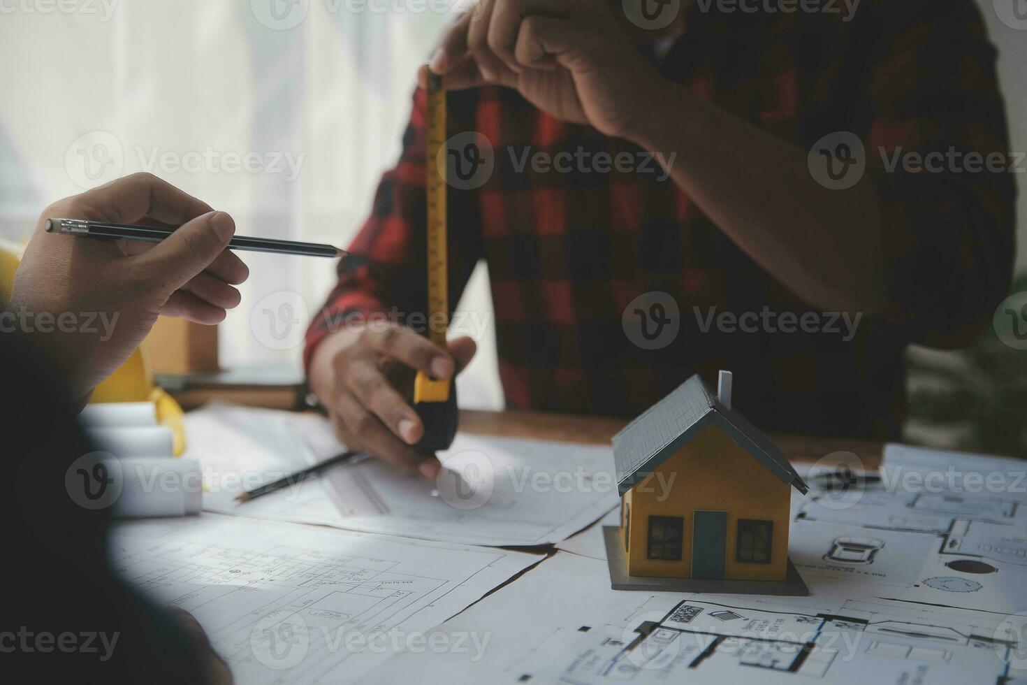 Close up of civil male engineer asian working on blueprint architectural project at construction site at desk in office. photo