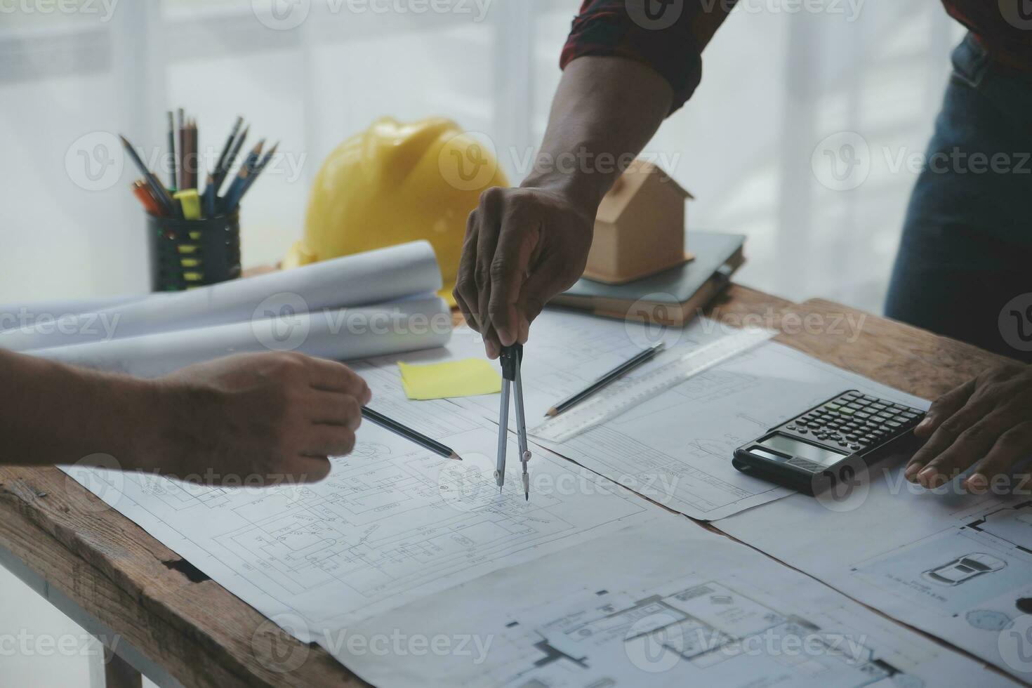 Close up of civil male engineer asian working on blueprint architectural project at construction site at desk in office. photo