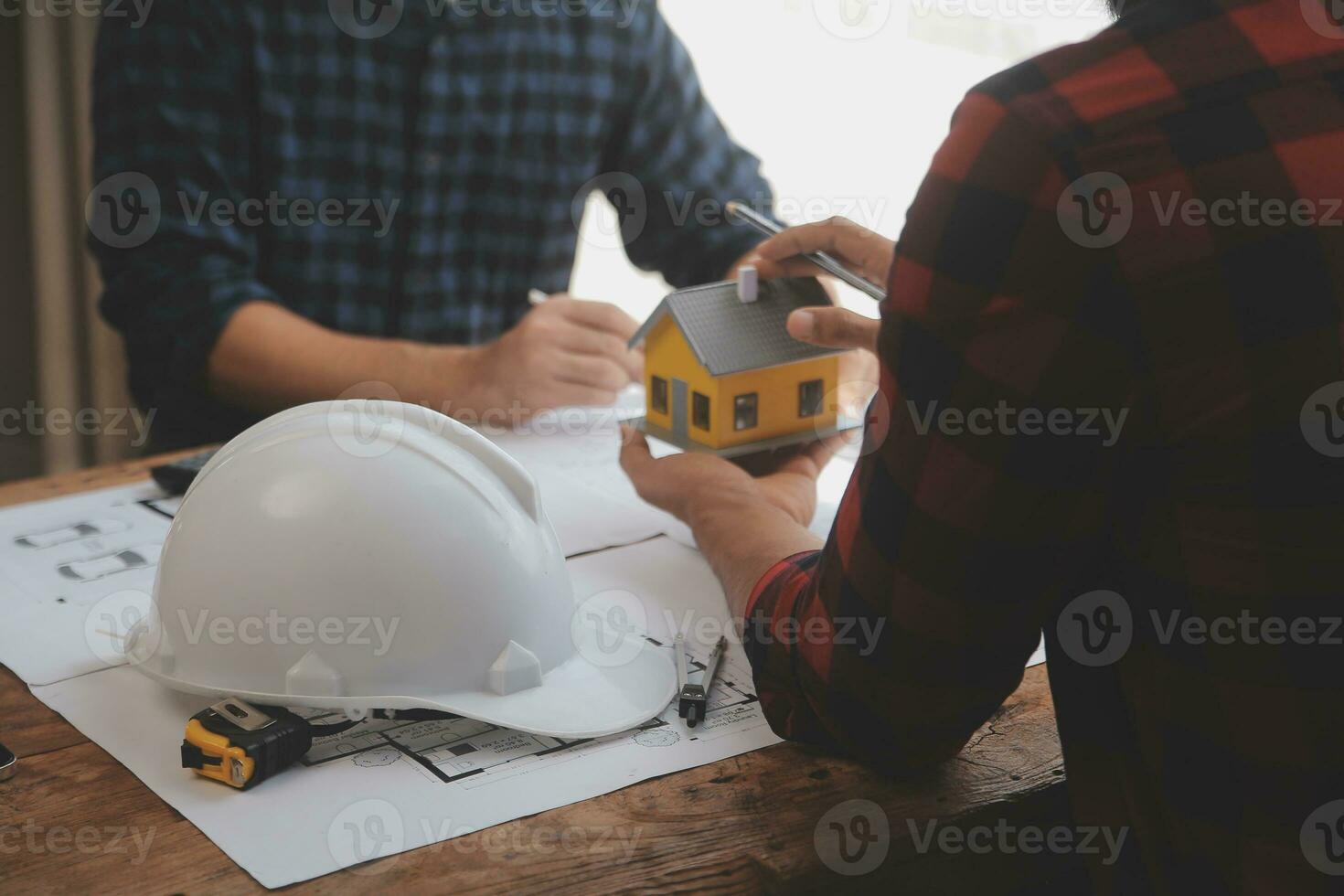 Close up of civil male engineer asian working on blueprint architectural project at construction site at desk in office. photo