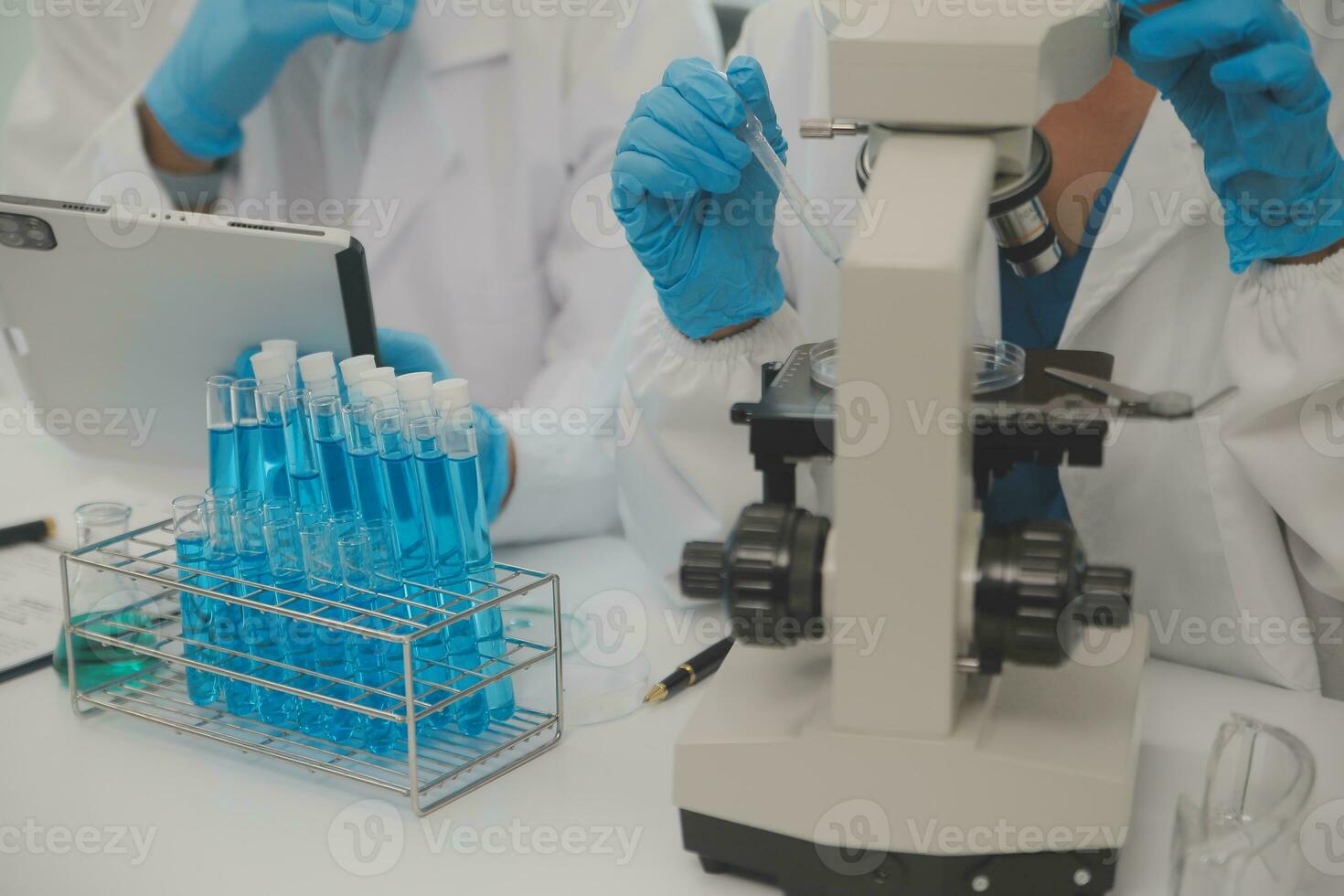 Health care researchers working in life science laboratory. Young female research scientist and senior male supervisor preparing and analyzing microscope slides in research lab. photo