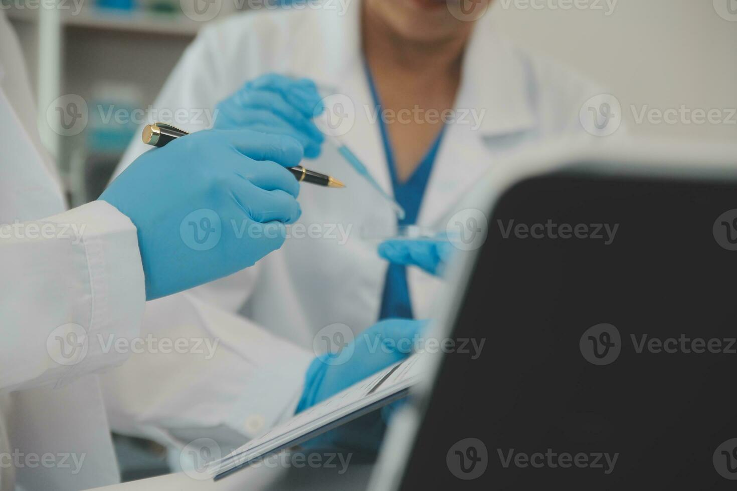 Health care researchers working in life science laboratory. Young female research scientist and senior male supervisor preparing and analyzing microscope slides in research lab. photo