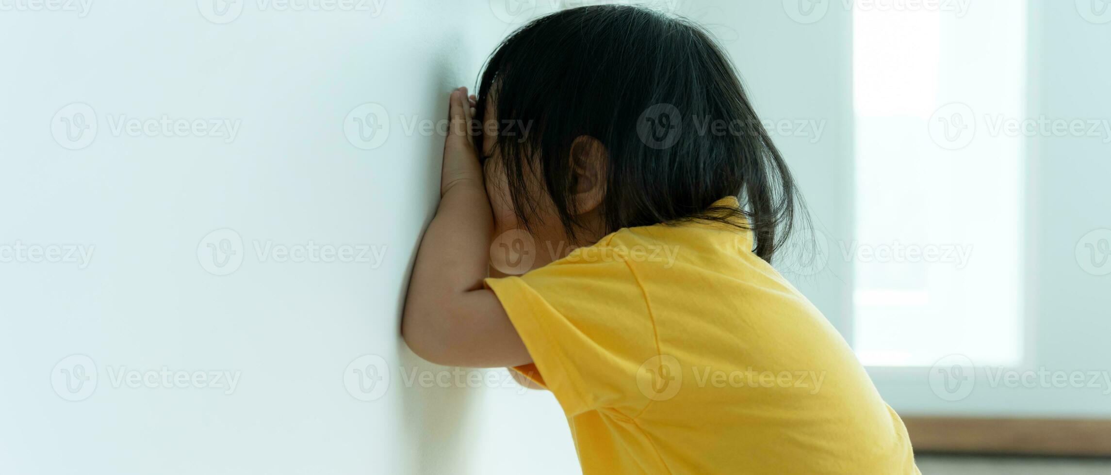 little asian children kid playing hide and seek standing next wall house, Adorable child having fun in the home. happy family have fun with kids, activity, learning, activity, game, meditation photo