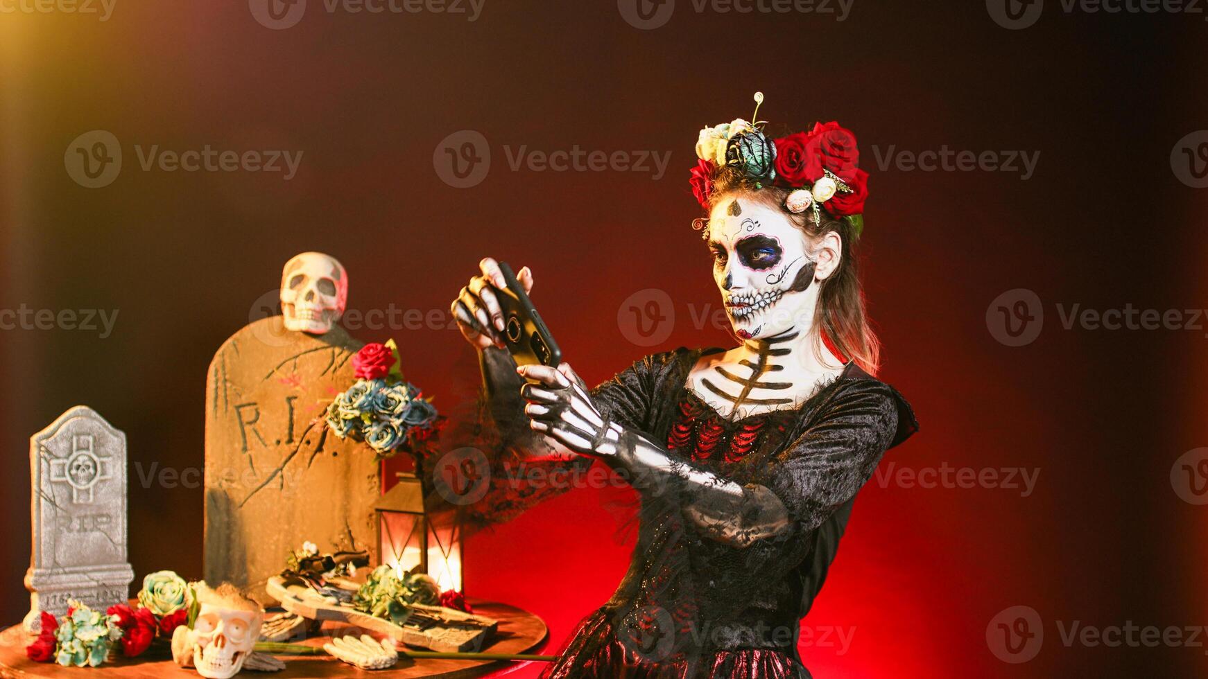 la cavalera catrina modelo jugando vídeo juegos en teléfono inteligente, utilizando móvil teléfono en línea en día de el muerto celebracion. Papa Noel muerte teniendo divertido en santo mexicano festival, escalofriante día festivo. foto