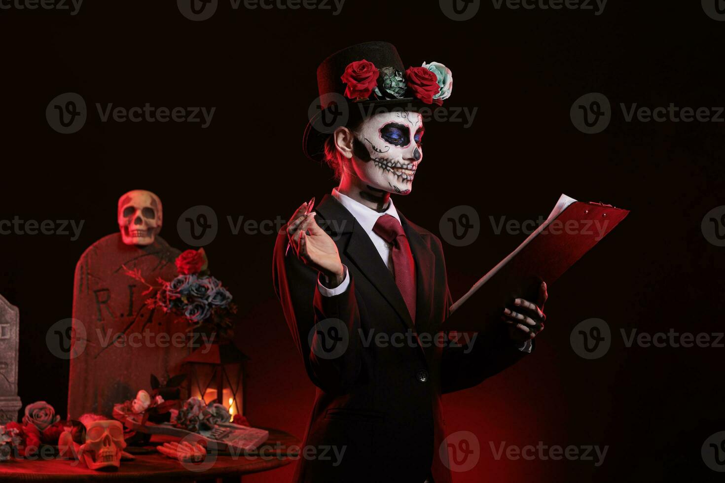 Scary person with day of the dead make up taking notes on clipboard papers, looking like santa muerte on dios de los muertos holiday celebration. Goddess of death traditional costume. photo