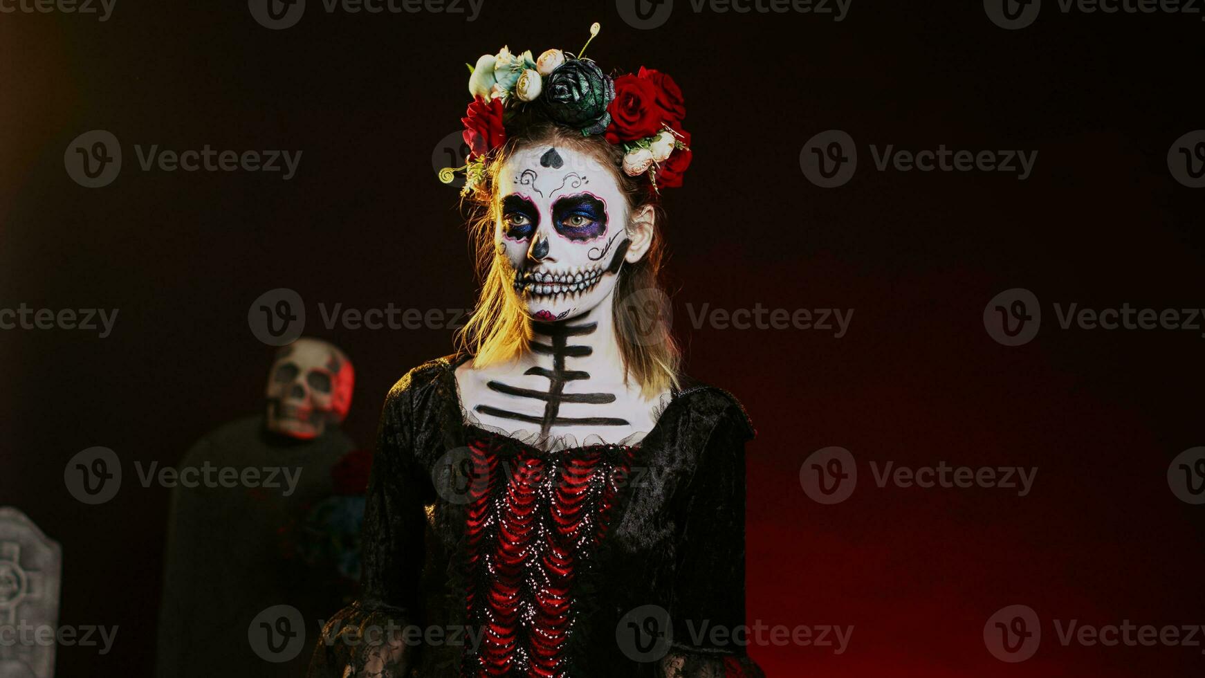 Beautiful lady of dead posing in halloween costume with skull make up to celebrate dios de los muertos on mexican holiday. Spooky woman as santa muerte with black and white body art. Handheld shot. photo