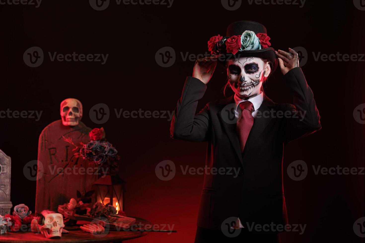 Beautiful model in costume with skull make up celebrating traditional mexican holiday with goddess of death costume. La cavalera catrina culture celebration with body art over black background. photo