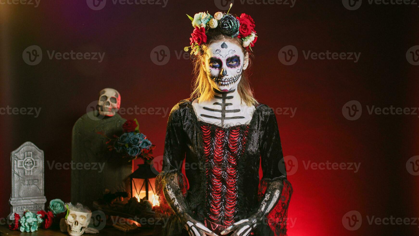 Spooky goddess of death with skull make up and horror costume to celebrate dios de los muertos on mexican halloween. Creepy woman dressed as santa muerte on day of the dead holiday. photo