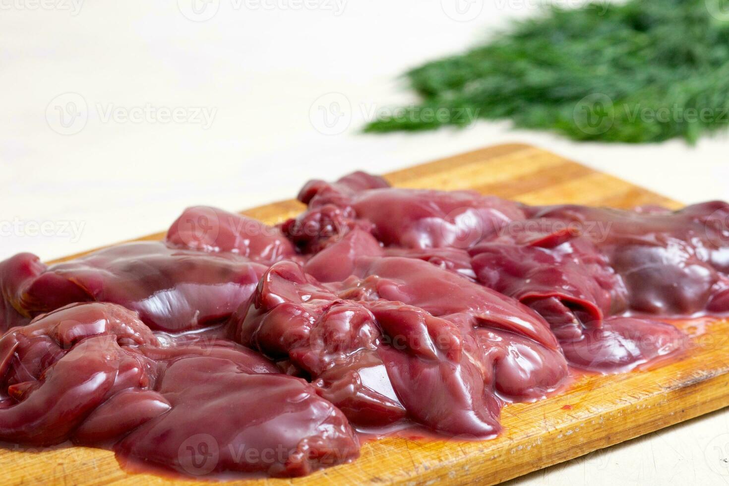 Raw chicken liver on cutting board photo