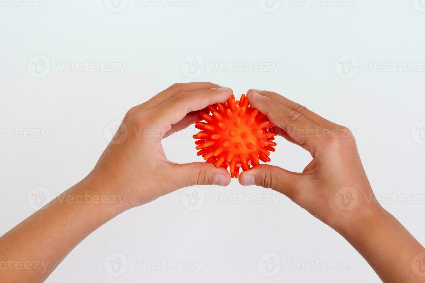 Cropped child hands doing exercise using spiky ball photo
