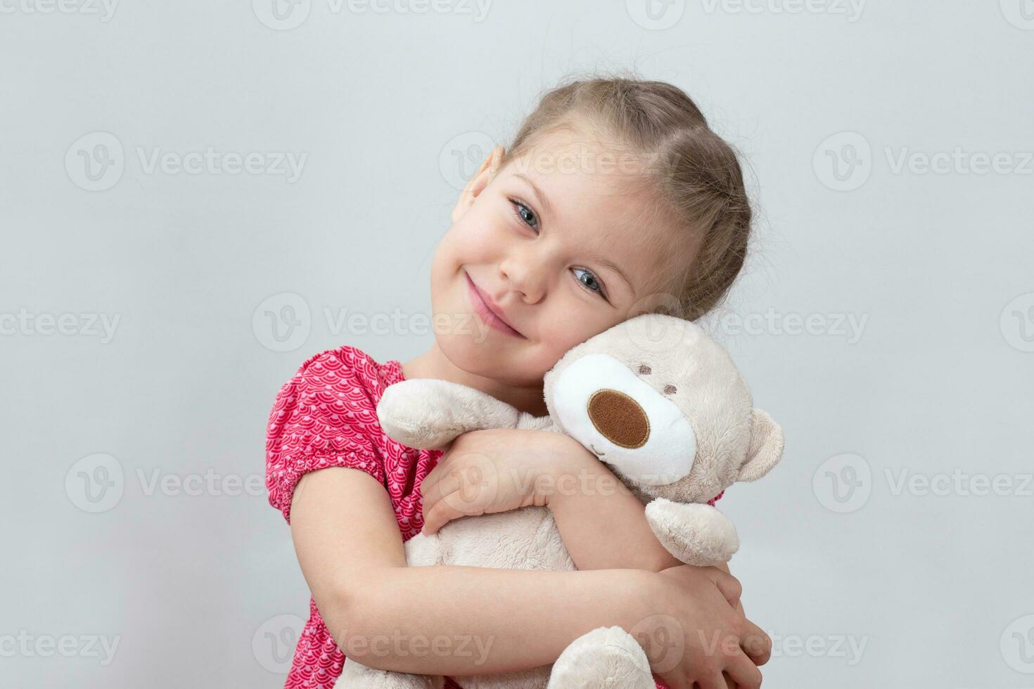 Happy child hugging teddy bear photo