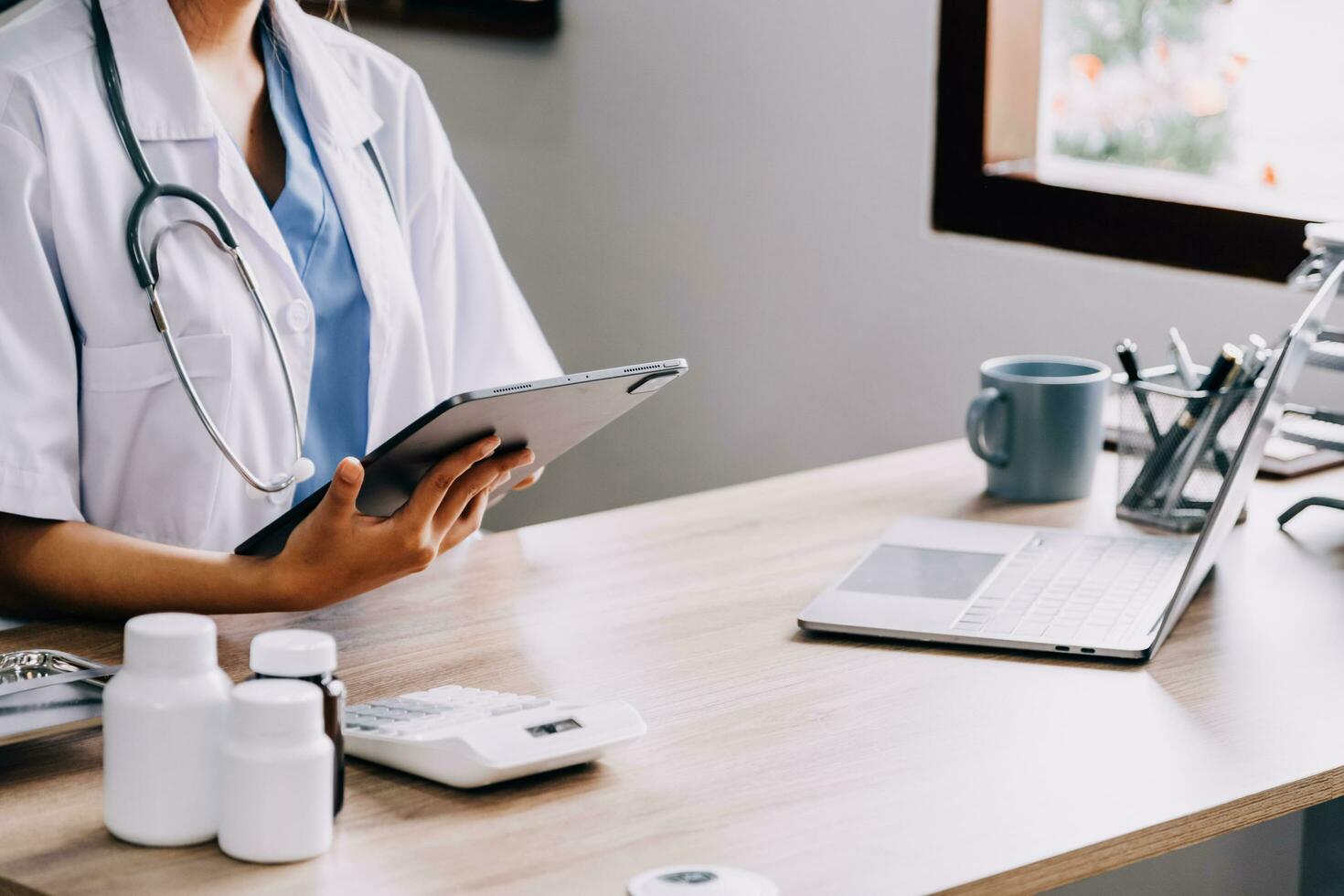 Medical doctor or physician consulting patient's health online using internet mobile digital tablet in clinic or hospital office for professional emergency healthcare assistance service concept photo