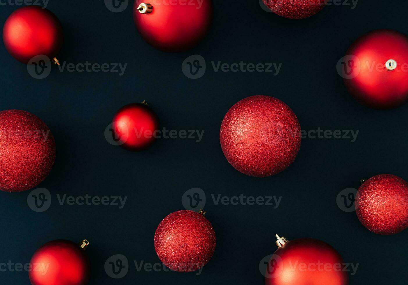 Red Christmas baubles decoration on black background. New Year party background. Minimal style. Creative Christmas or New Year concept. Fancy winter holidays pattern idea. Flat lay, top of view. photo