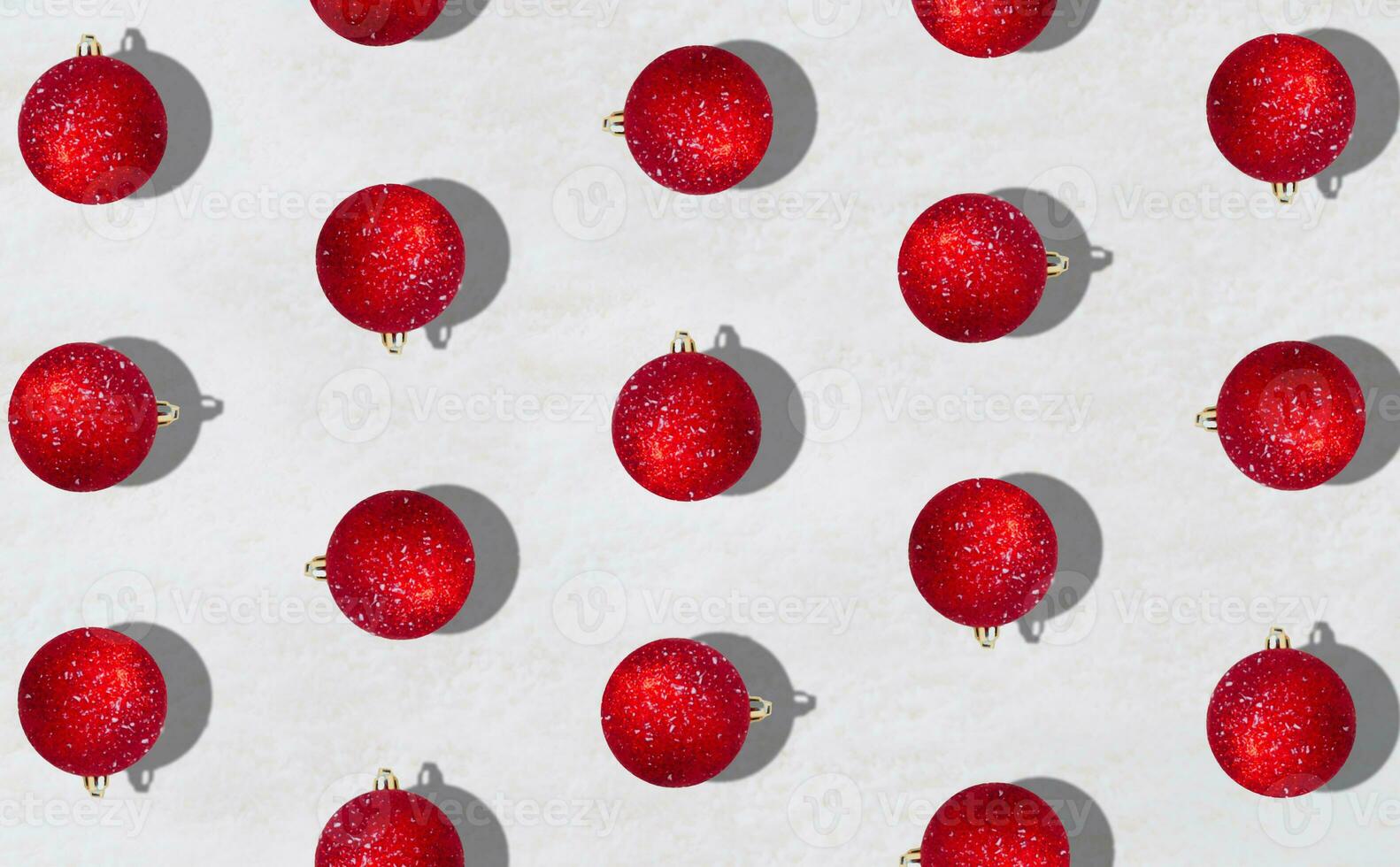 Creative trendy pattern made with red Christmas baubles on snowy background. Minimal Christmas or New Year concept. Winter holidays idea. Flat lay composition. Top of view. photo