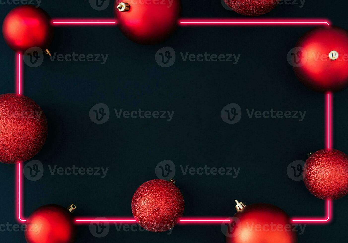 Red Christmas baubles decoration with neon light frame on black background. New Year party background. Minimal style. Creative Christmas or New Year concept. Winter holidays pattern idea. Flat lay. photo