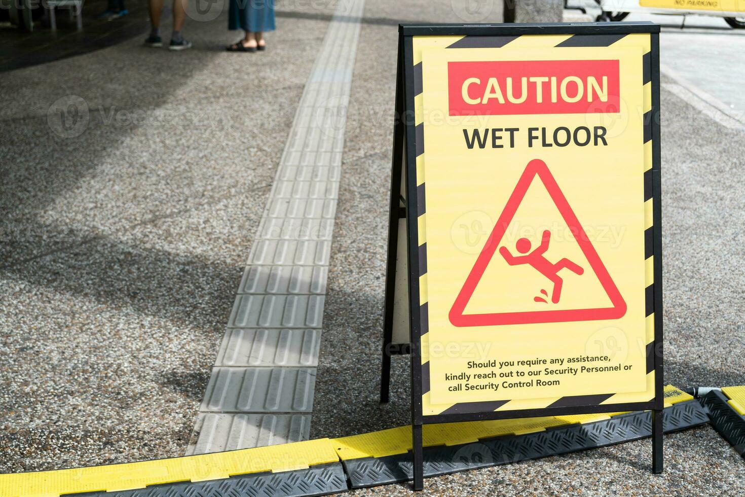 Sign showing warning of caution wet floor on the pathway. photo