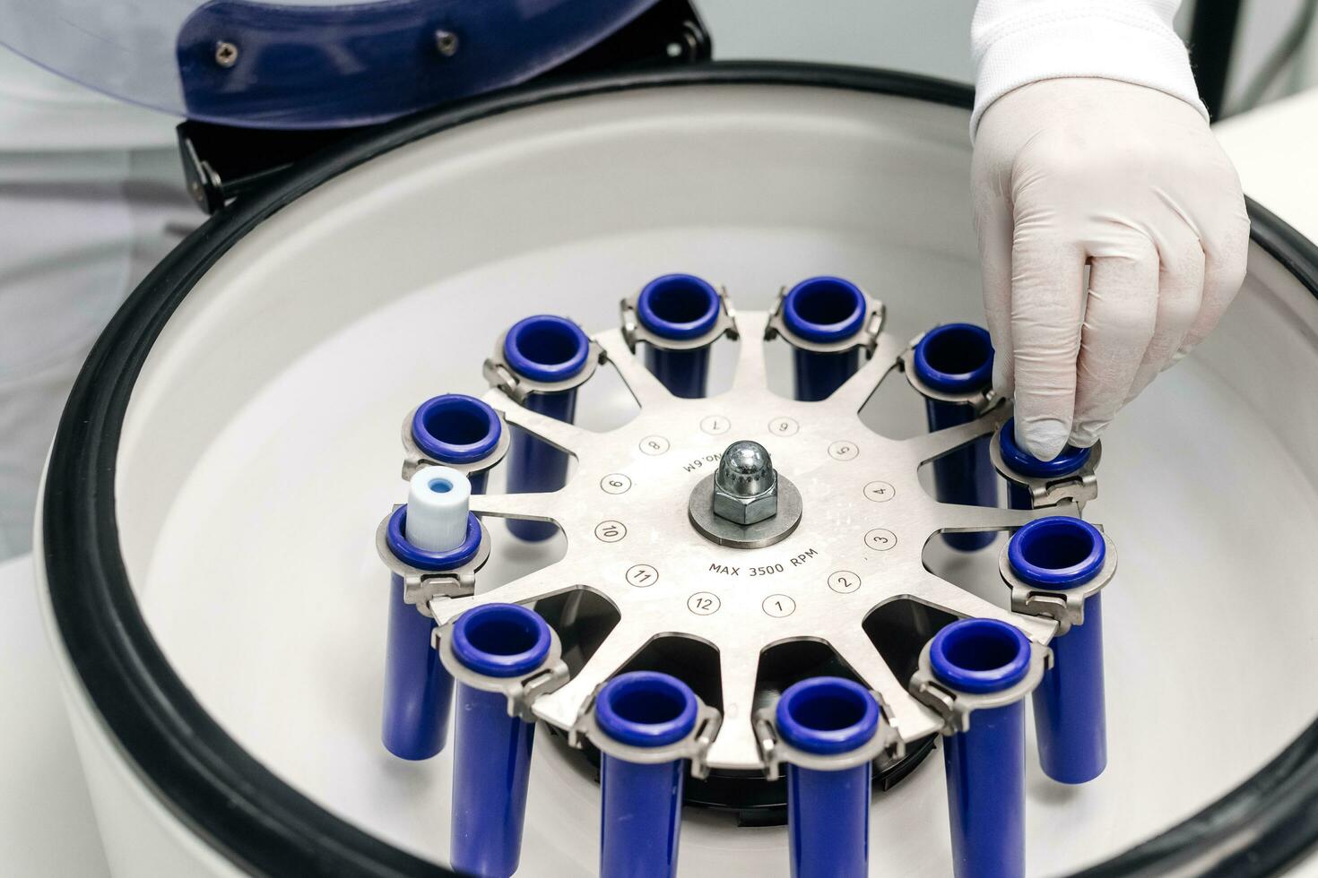 Cosmetologist extracting blood plasma using a centrifuge. The doctor takes out tubes with blood plasma. photo