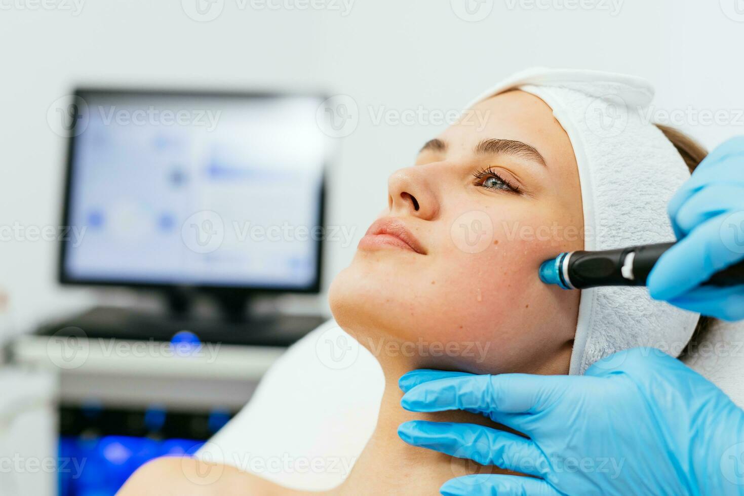 cara piel cuidado. de cerca de mujer consiguiendo facial hidro microdermabrasión peladura tratamiento a cosmético belleza spa clínica. hidra vacío limpiador. exfoliación, rejuvenecimiento y hidratación cosmetología. foto