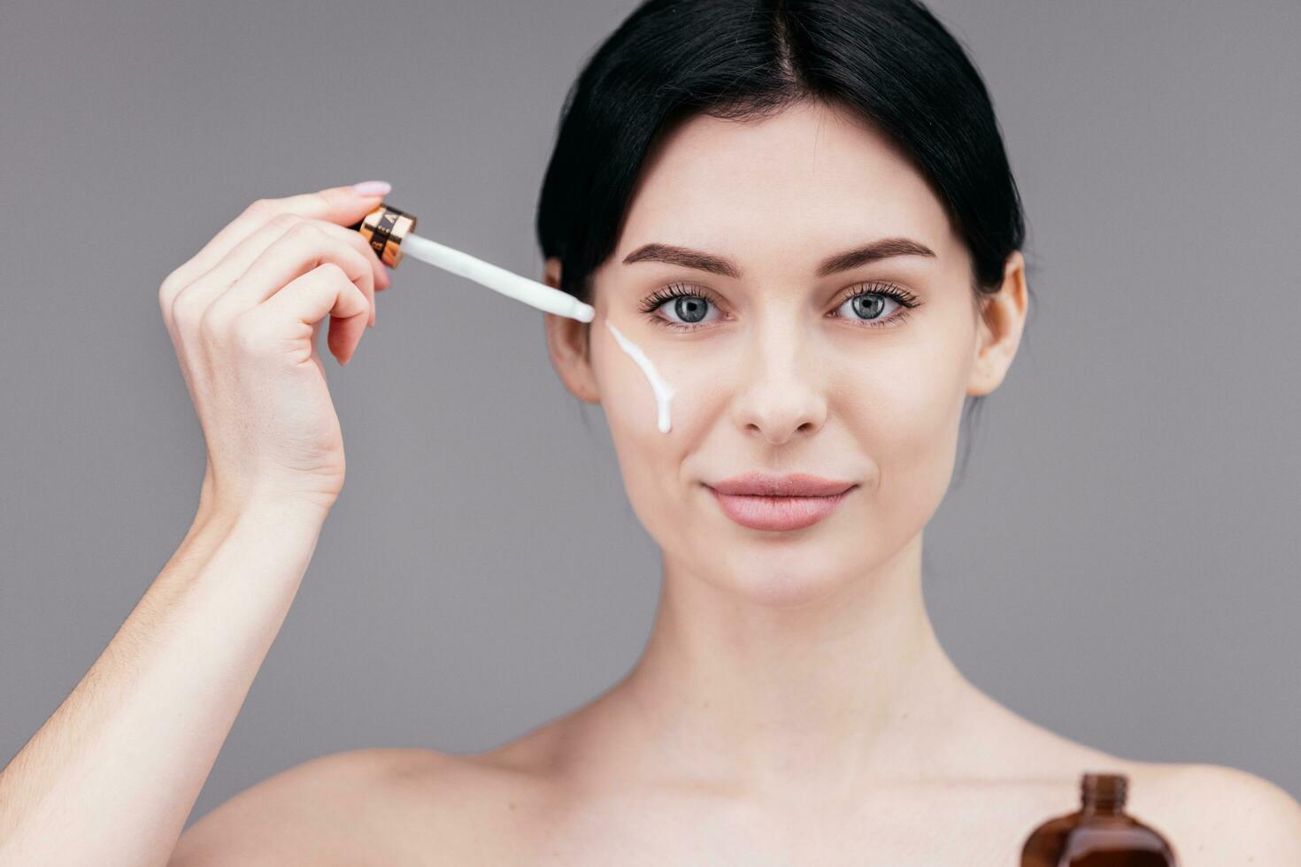 cerca arriba de mujer cuerpo cuidado a hogar. retrato de mujer aplicando hidratante crema en cuello. natural piel cuidado foto