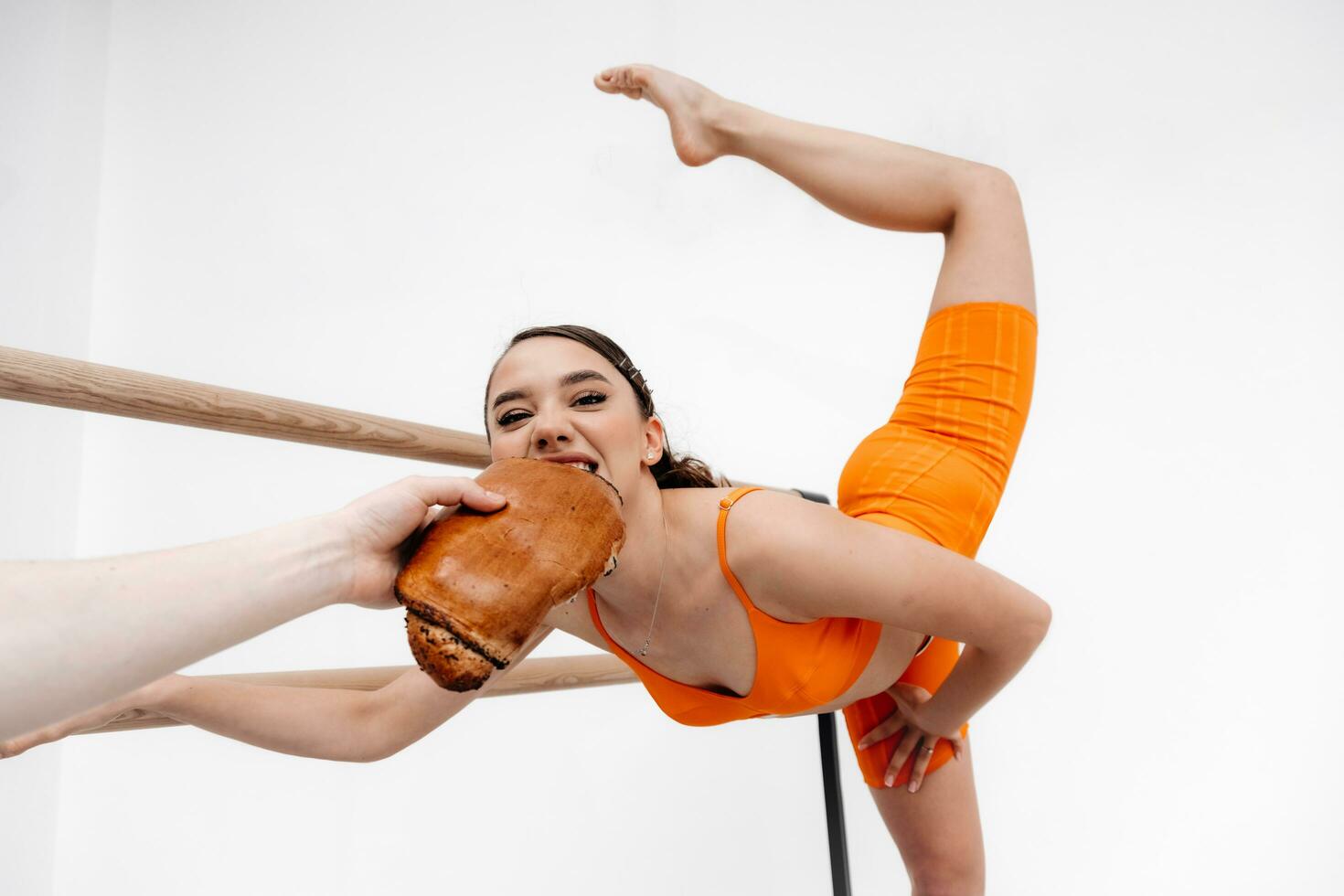 Young Hungry girl, sportswoman eat a bun, bread, bakery. Enjoying unhealthy eating. Junk food, diet concept photo