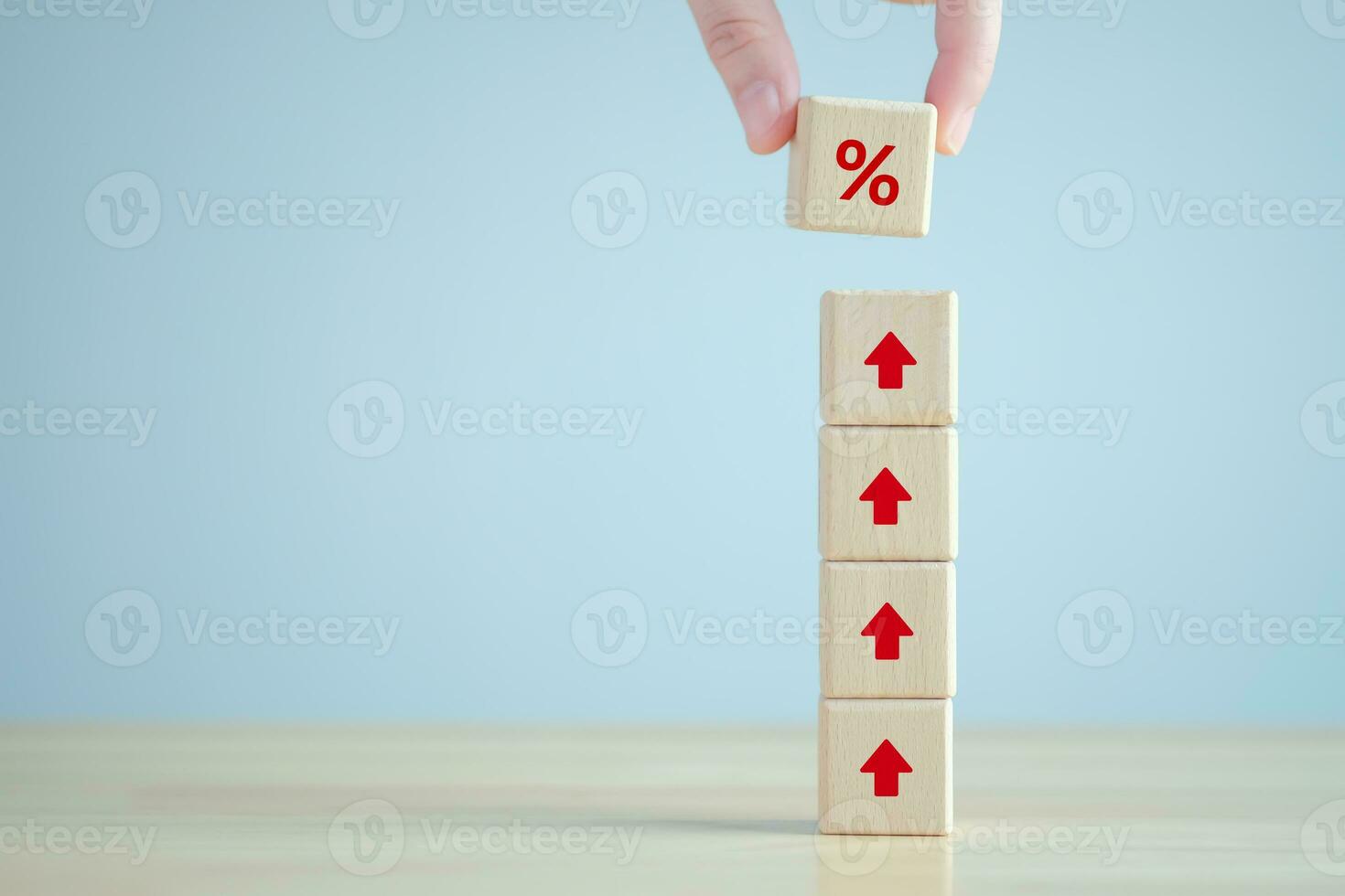 Interest rate finance and mortgage rates. Hand holding percentage sign from rise of arrow up on wooden stack. financial growth, interest rate increase, inflation, sale price and tax rise concept. photo