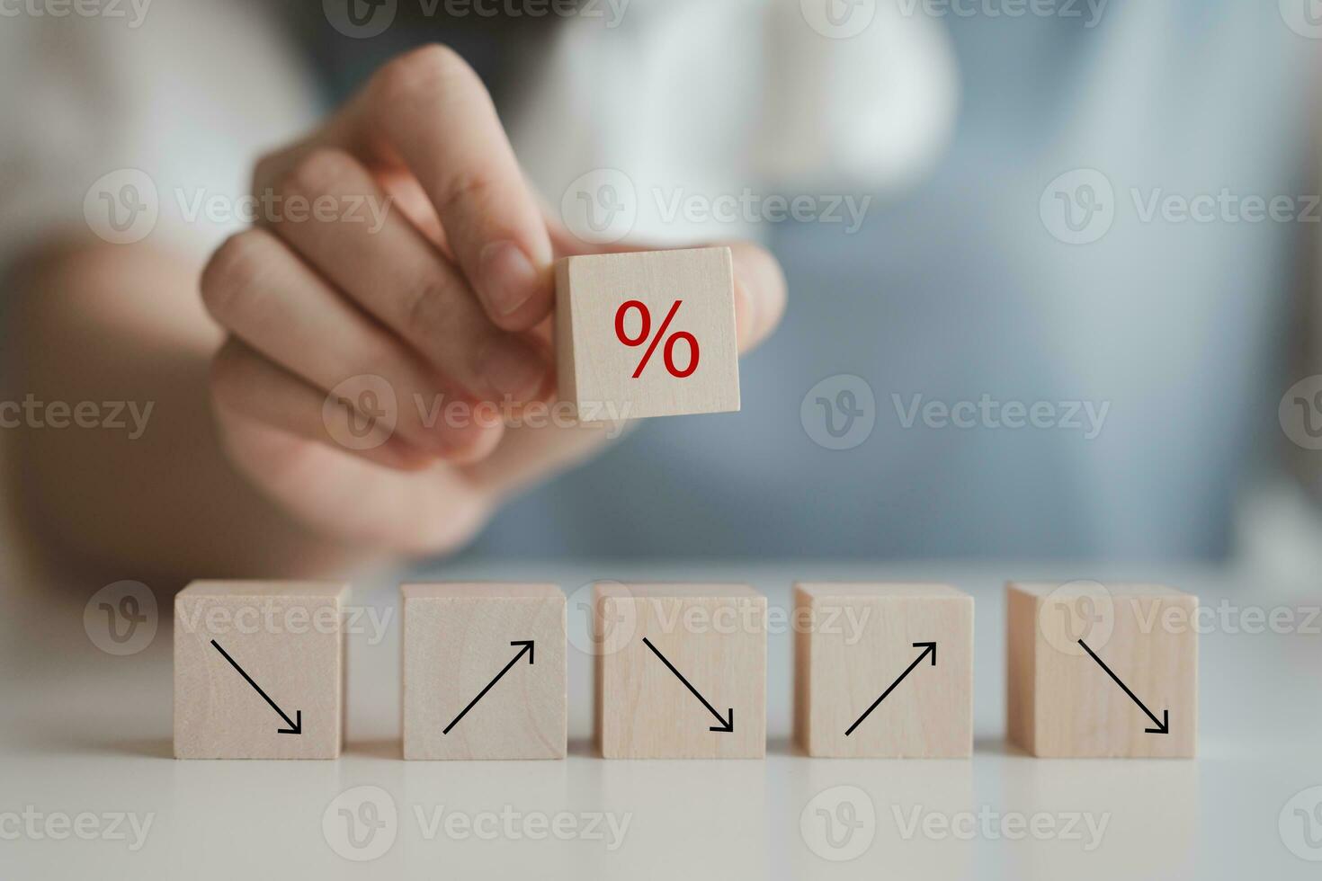 Hand hold percentage sign on wood block and arrow up and down. Interest rate increase or decrease and mortgage rates, business and financial growth, inflation, sale price and tax rise concept. photo