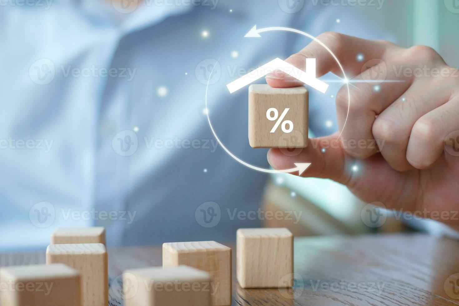 Refinance to reduce the interest of home loan. Hand holding percentage sign with roof house. Mortgage, loan, repayments, credit limit, interest rate, business and financial concept. photo