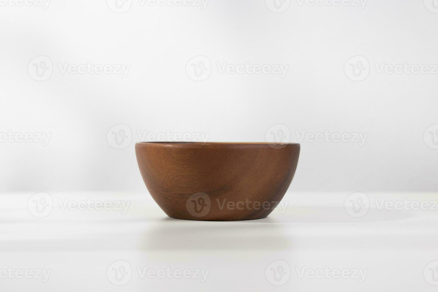 A vacant wooden bowl on the table and a white background in the morning. photo
